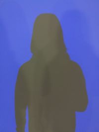 Silhouette of woman against blue sky