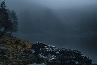 Scenic view of lake by mountain during winter