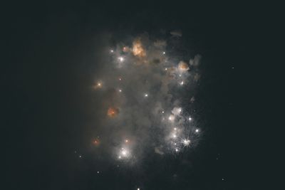 Low angle view of firework display at night
