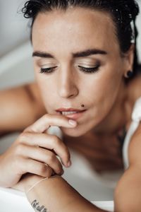 Close-up of woman face relaxing in bathtub