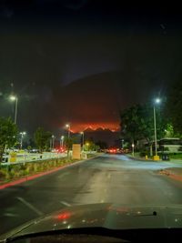 Illuminated road seen through car windshield at night