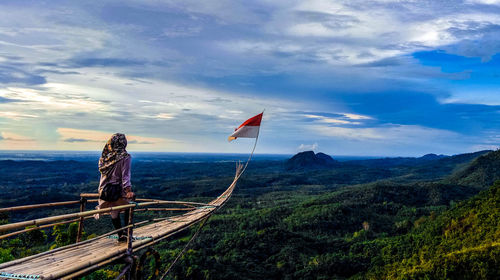 Woman on mountain against sky