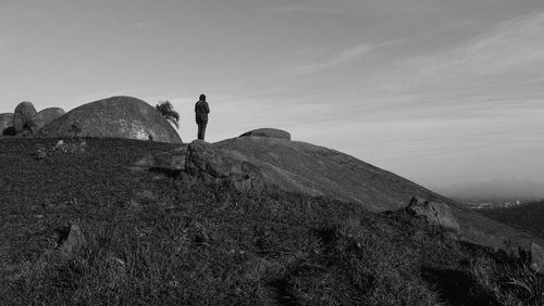 Woman standing on hill against sky