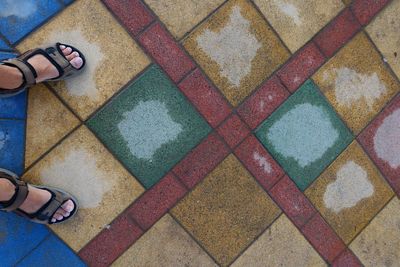 Low section of person standing on tiled floor