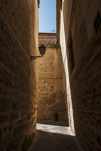 Low angle view of alley amidst buildings against sky