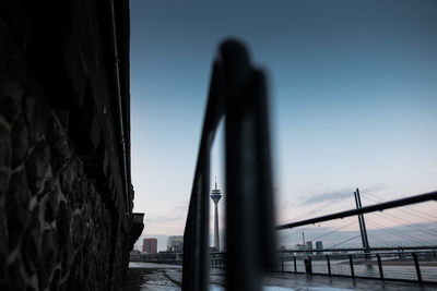 Suspension bridge in city against clear sky