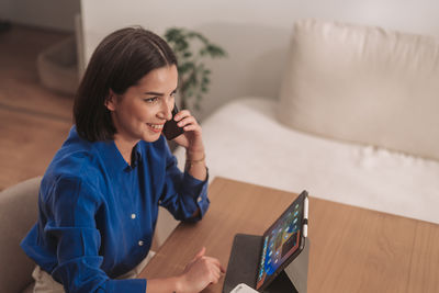 Young woman using mobile phone at home