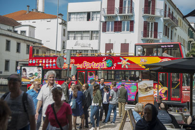 People walking on street against buildings in city