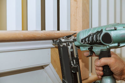Cropped hand using nail gun on at home