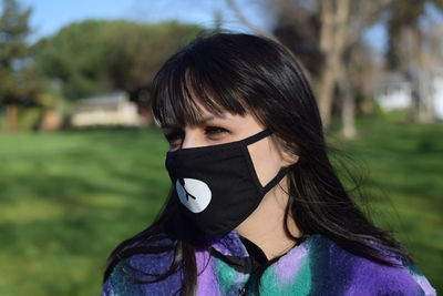 Portrait of woman covering face on field