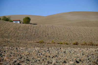 Scenic view of desert against clear blue sky