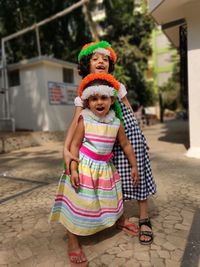 Full length portrait of sisters standing on street