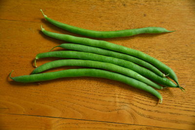 High angle view of green beans on wooden table