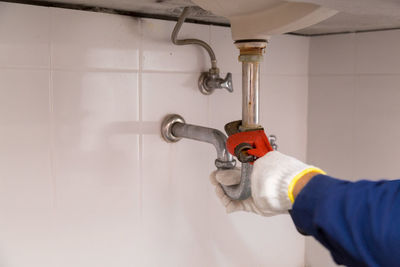 Close-up of man working against wall