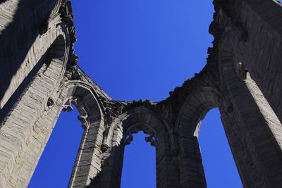 Low angle view of historical building against clear blue sky