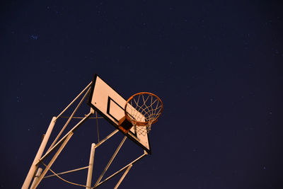 Low angle view of basketball hoop against sky at night
