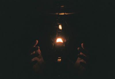 Close-up of hand on illuminated lighting equipment