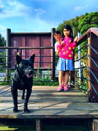 Full length of woman with dog on railing