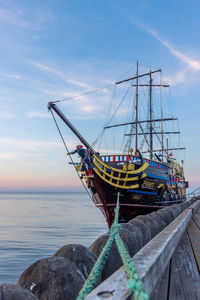 Fishing boat moored in sea against sky