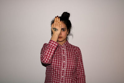 Young woman looking at camera against white background