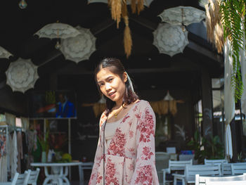 A woman wearing a red dress in a coffee shop atmosphere at coffee shop called nature park , thailand
