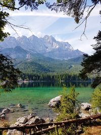 Scenic view of lake by snowcapped mountains against sky