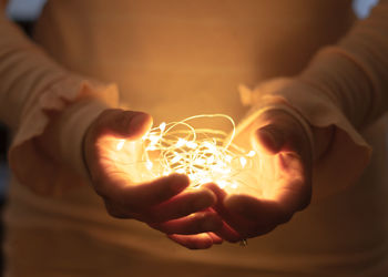 Close-up of hand holding illuminated lighting equipment