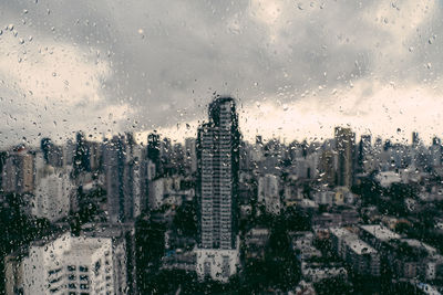 City buildings seen through wet glass window