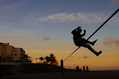 Silhouette people against sky during sunset