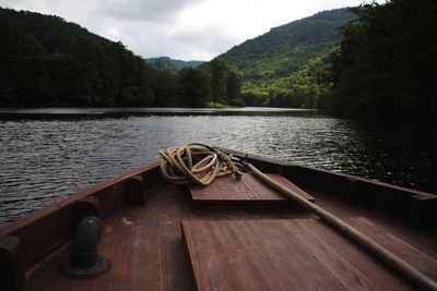 Rope on boat deck in river against mountains