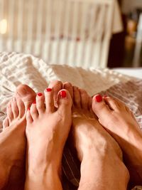 Low section of woman resting on bed