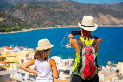 Rear view of woman wearing hat standing at beach