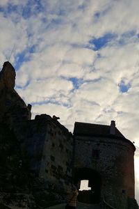 Low angle view of building against cloudy sky