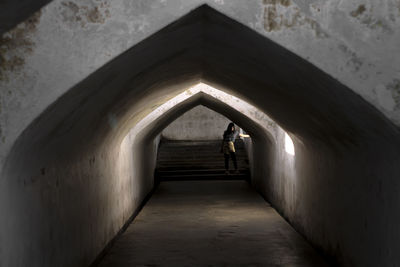 Rear view of man on footpath in tunnel