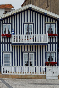 Typical colourful houses with blue and white stripes in costa nova - aveiro against sky