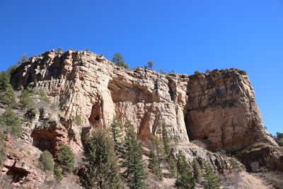 Panoramic view of cliff against clear blue sky