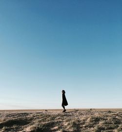 Side view of man standing on land against clear sky