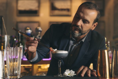 Male bartender preparing cocktail at bar counter