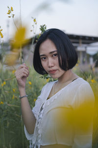 Portrait of a beautiful young woman holding red flower