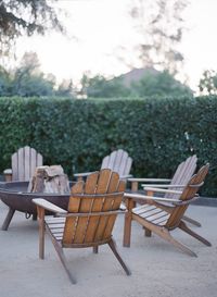 Chairs and table by trees against sky