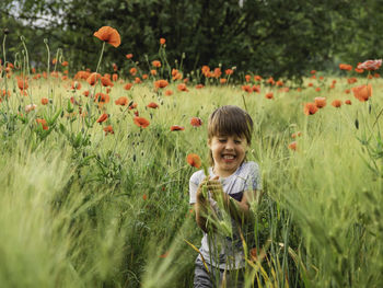 Boy enjoying amidst flowers in field