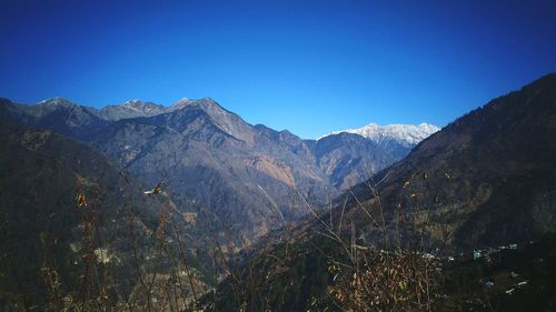 Scenic view of mountains against clear blue sky