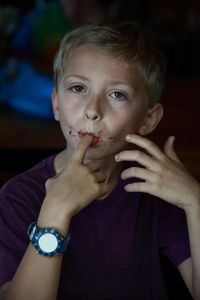 Portrait of boy licking finger