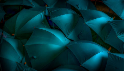 Full frame shot of turquoise umbrellas at night