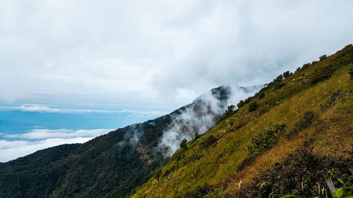 Scenic view of mountains against cloudy sky