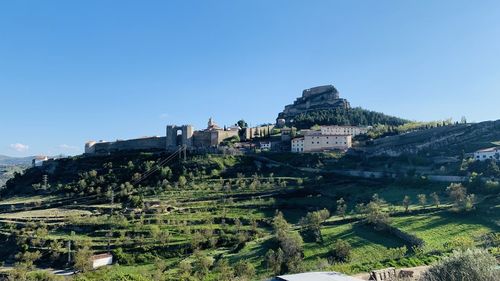 Castle in town against clear blue sky