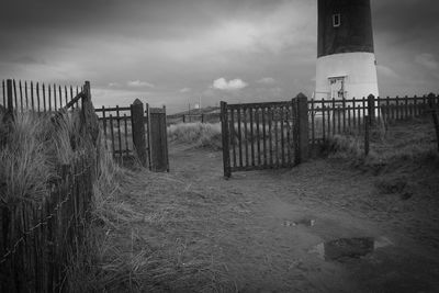 Wooden posts on field against sky