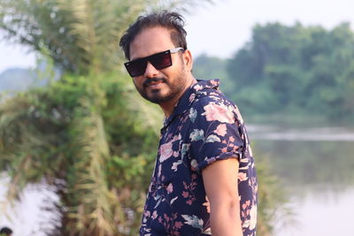 Portrait of young man wearing sunglasses standing outdoors