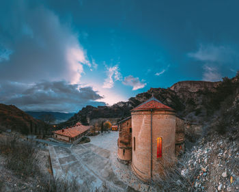 View of building by mountain against sky