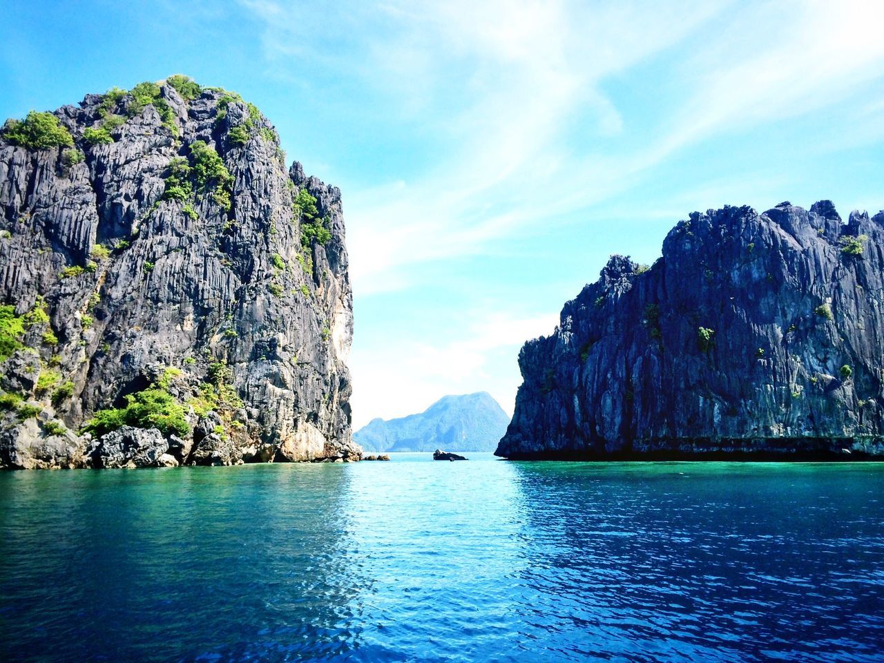 water, mountain, tranquil scene, scenics, tranquility, beauty in nature, waterfront, rock formation, mountain range, sky, nature, sea, rock - object, cliff, rocky mountains, lake, idyllic, blue, rock, geology